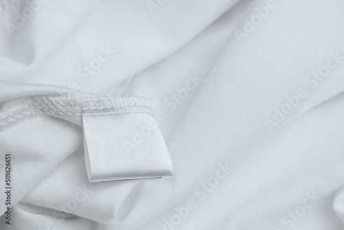 Blank label for composition and description of fabric on a background of white clothing texture. Wardrobe care.