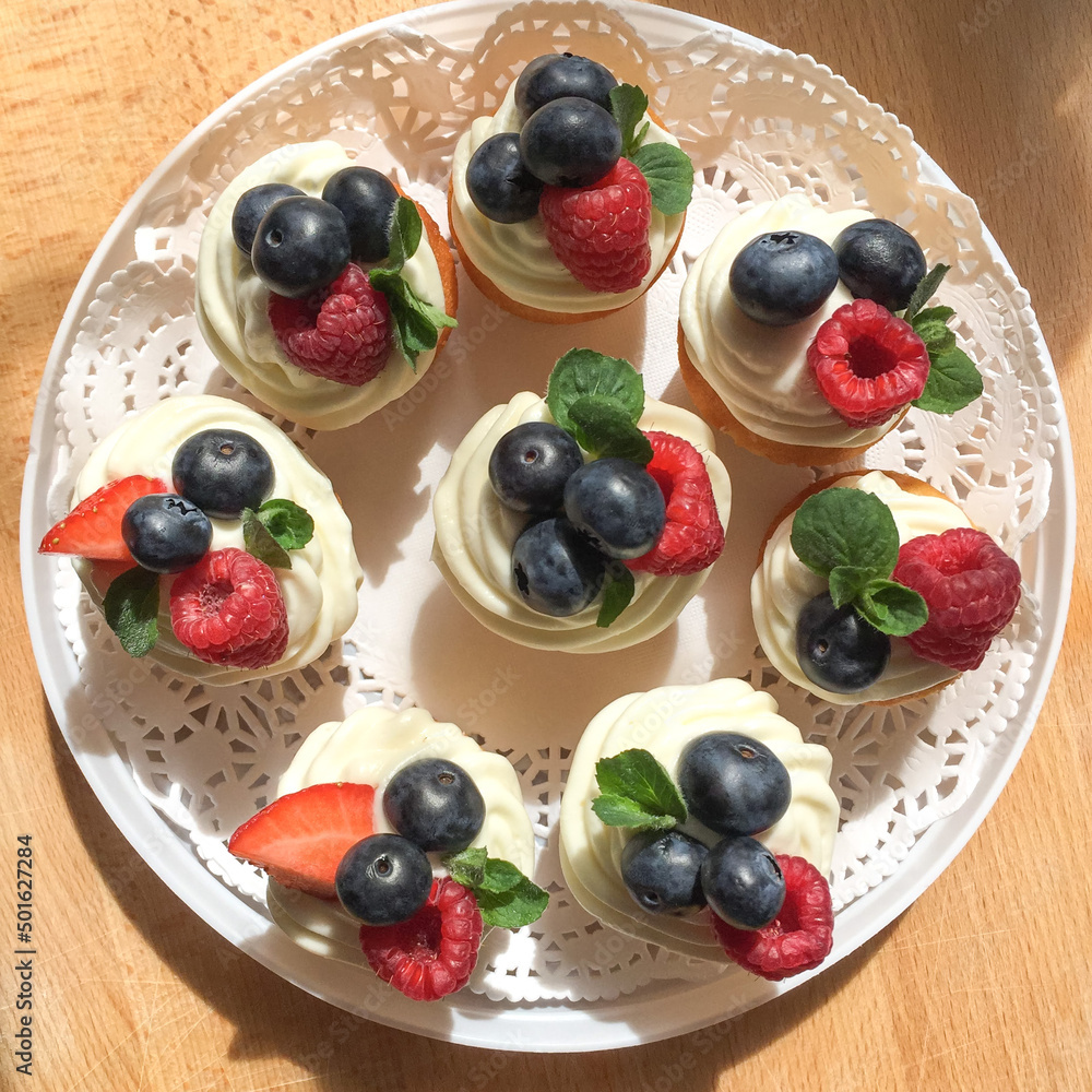 Home made cupcakes with cream and fresh berries. freshly baked desserts. Home made cupcakes with cream and fresh berries. freshly baked desserts.