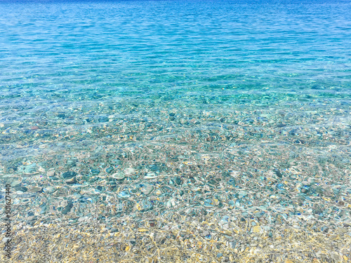 Sea background. Aegean sea, turquoise blue clear water and white sand on the beach. Natural sea background