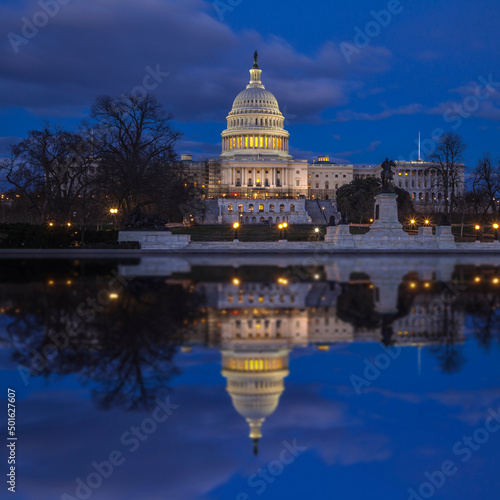 US Capitol building reflecting off a pool at twilight