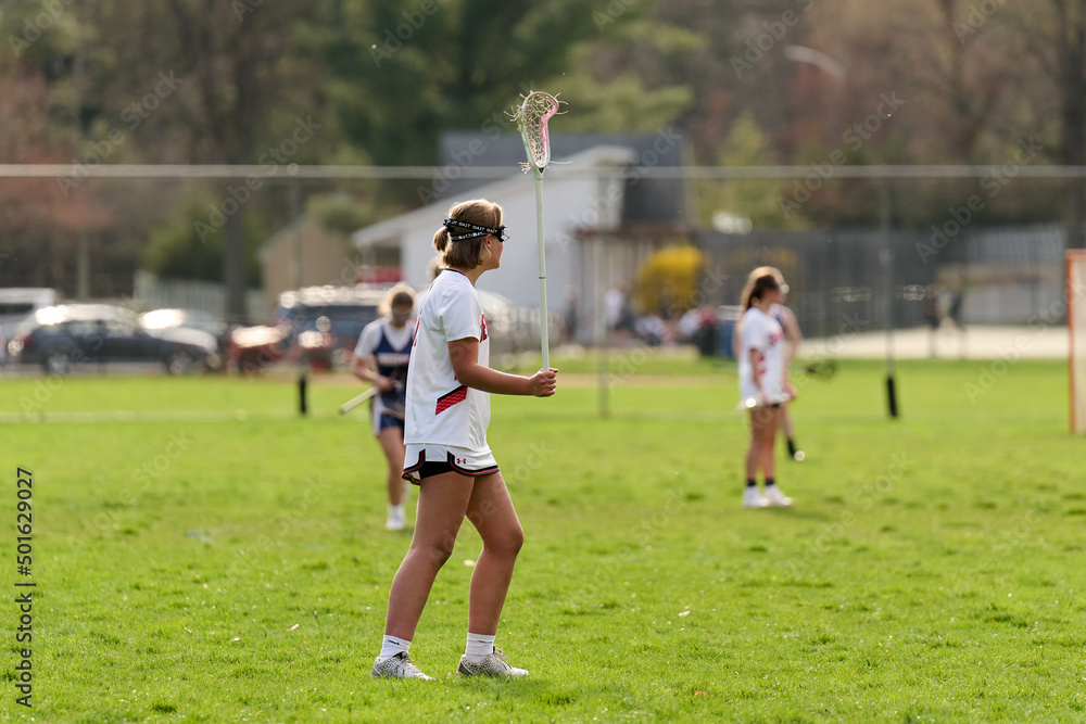 Obraz premium SEWICKLEY, PA, USA - APRIL13th 2022: Teenage girls from Sewickley Academy play senior school varsity lacrosse game against Freeport High School. There were lots of goals and action on this sunny day.