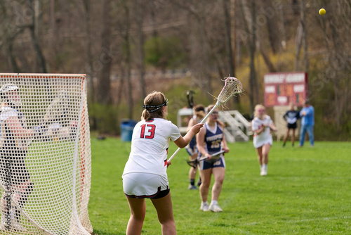 SEWICKLEY, PA, USA - APRIL13th 2022: Teenage girls from Sewickley Academy play senior school varsity lacrosse game against Freeport High School. There were lots of goals and action on this sunny day. photo