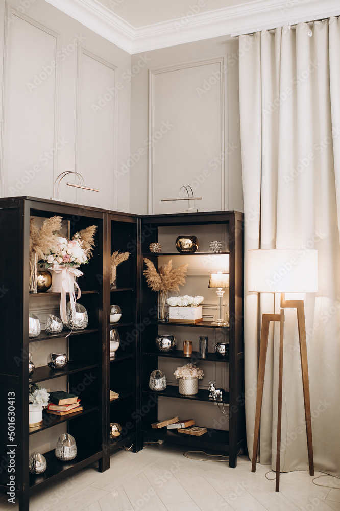 interior in an apartment with a floor lamp and shelves with trinkets interior in an apartment with a floor lamp and shelves with trinkets