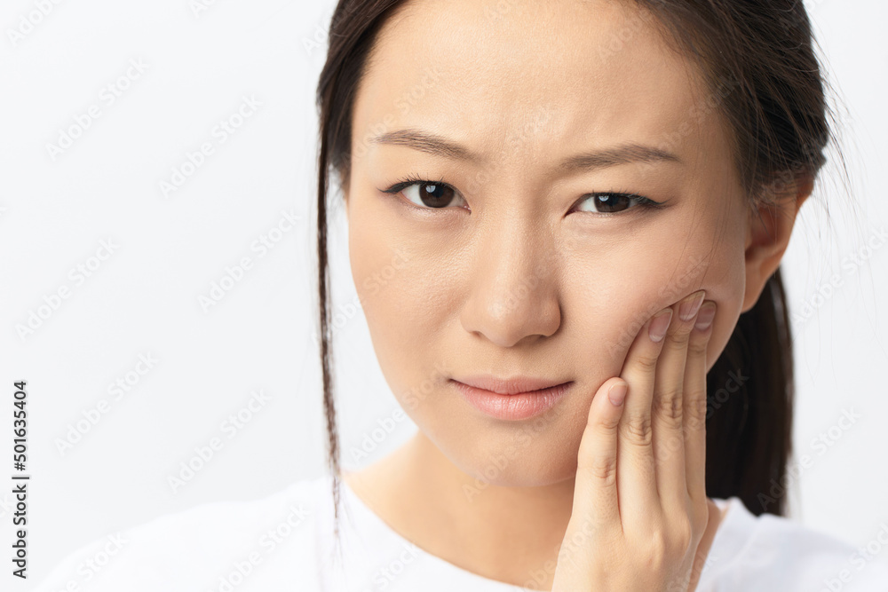 Gumboil Dental abscess Wisdom teeth Periodontitis. Unhappy suffering tanned pretty young Asian woman touch cheek posing isolated on white background. Injuries Poor health Illness concept. Cool offer Gumboil Dental abscess Wisdom teeth Periodontitis. Unhappy suffering tanned pretty young Asian woman touch cheek posing isolated on white background. Injuries Poor health Illness concept. Cool offer
