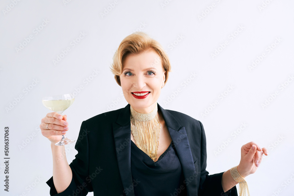 mature stylish elegant woman in tuxedo with glass of sparkling wine. Party, celebration, anti age concept mature stylish elegant woman in tuxedo with glass of sparkling wine. Party, celebration, anti age concept
