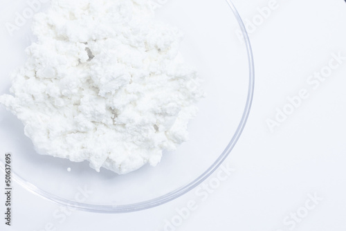 cottage cheese in a glass transparent bowl isolated on a white background © belavinstock