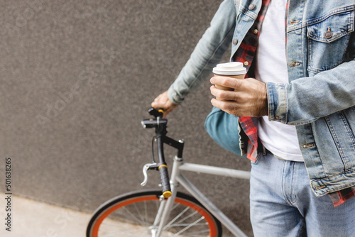 Cup of hot coffee in hands of a bicycle commuter