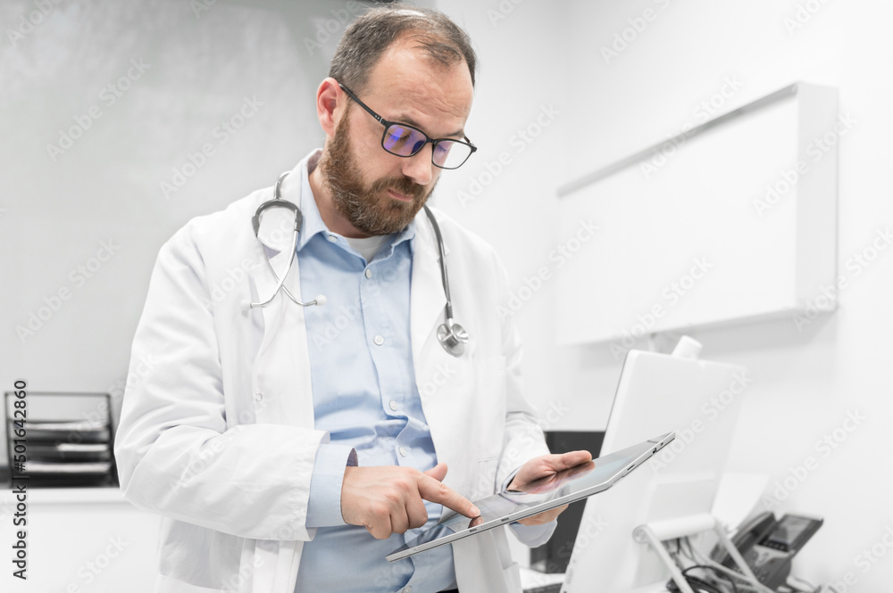 Male doctor with white coat and stethoscope using tablet, network connection in hospital room, Medical technology network concept. High quality photography. Male doctor with white coat and stethoscope using tablet, network connection in hospital room, Medical technology network concept. High quality photography.