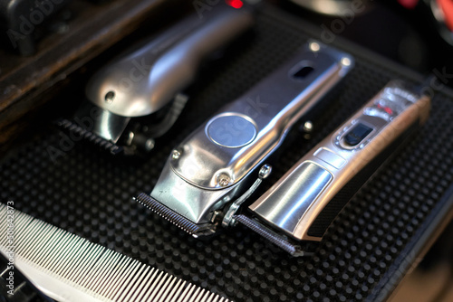 Three hair clippers on a rubber surface in a barber shop