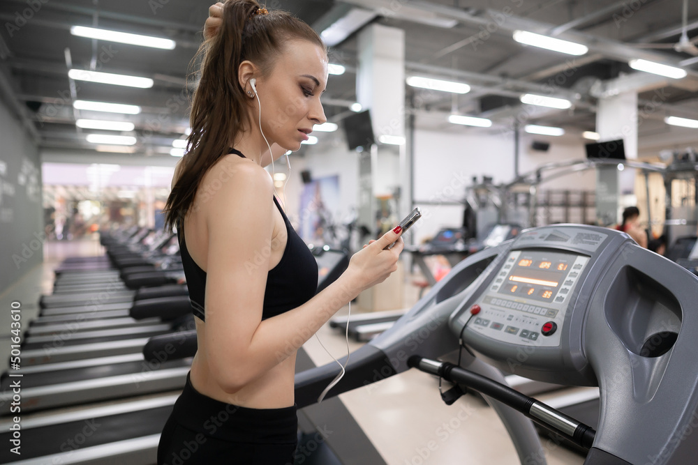 Fototapeta premium Adult woman running on treadmill