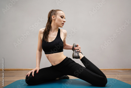 Fitness, sport, training and lifestyle concept - woman stretching on mat in the gym