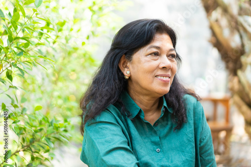 Fotografie Portrait of asian old woman 60s smile looking camera on green nature background