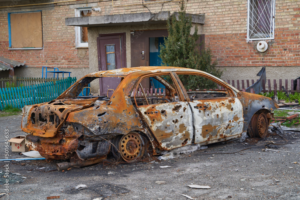 2022 Russian invasion of Ukraine war. War ruins city damage car. Terror attack bomb shell of civilian bombed. Disaster area. cars beaten by shrapnel and burnt