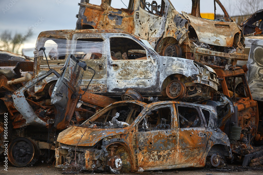2022 Russian invasion of Ukraine war. War ruins city damage car. Terror attack bomb shell of civilian bombed. Disaster area. cars beaten by shrapnel and burnt 2022 Russian invasion of Ukraine war. War ruins city damage car. Terror attack bomb shell of civilian bombed. Disaster area. cars beaten by shrapnel and burnt