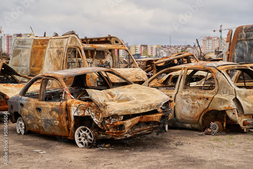 2022 Russian invasion of Ukraine war. War ruins city damage car. Terror attack bomb shell of civilian bombed. Disaster area. cars beaten by shrapnel and burnt photo