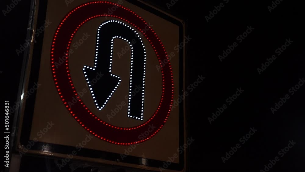Señal de transito de retorno en la noche, encendiéndose y apagándose en 4k