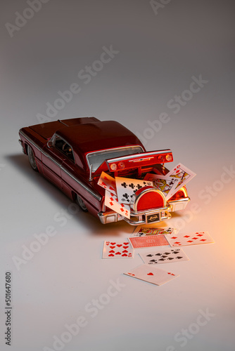Game cards in the trunk of a toy car, full house
