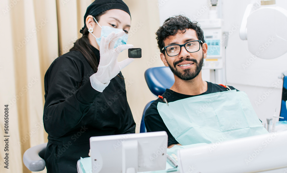 Dentist with patient showing him a periapical xray, View of dentist
