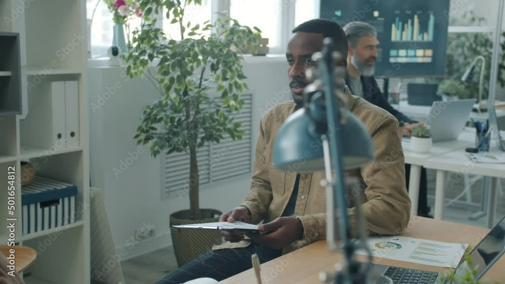 Slow motion portrait of entrepreneur consulting client in office sitting at desk together. Experienced businessman giving advice to your woman. Slow motion portrait of entrepreneur consulting client in office sitting at desk together. Experienced businessman giving advice to your woman.