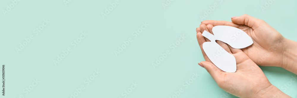 Female hands holding paper lungs on light blue background with space for text - obrazy, fototapety, plakaty 