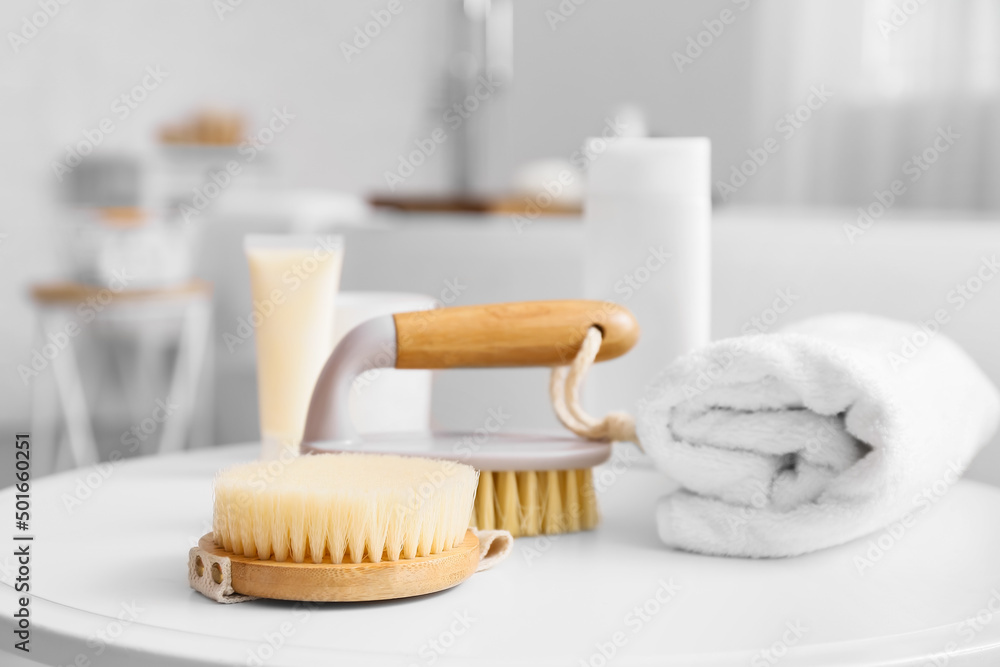 Body massage brushes and rolled towel on table Body massage brushes and rolled towel on table