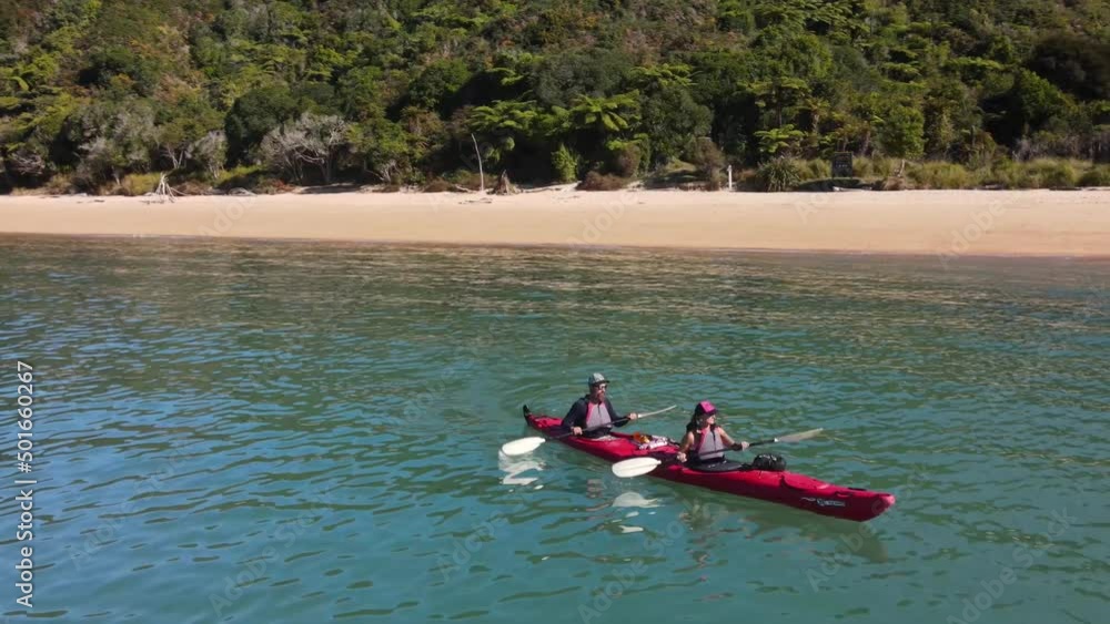 Couple sea kayaking at world famous tourist attraction in New Zealand. Sunny day in paradise, beautiful coastal scenery, Abel Tasman. Couple sea kayaking at world famous tourist attraction in New Zealand. Sunny day in paradise, beautiful coastal scenery, Abel Tasman.