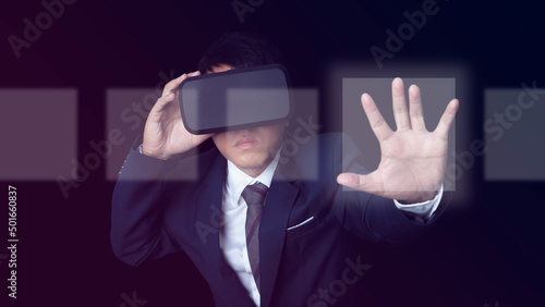 Man wearing VR Headset touching on a touch screen interface on neon color background.