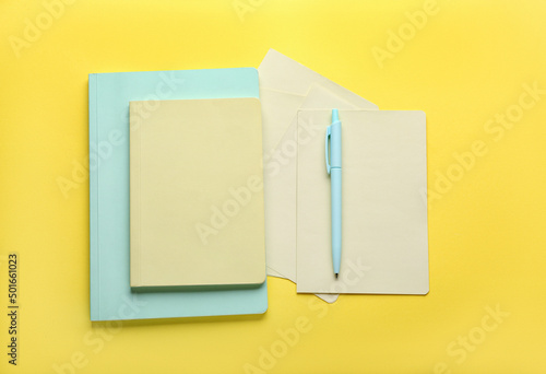 Notebooks and pen on yellow...