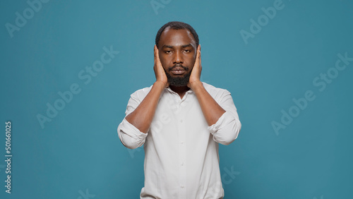 Photography African american man doing three wise monkeys symbol, covering eyes, mouth and ears to keep secret and not find out confidential information