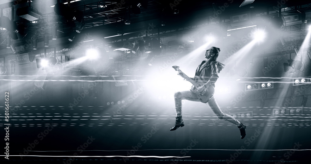 Young and beautiful rock girl playing the electric guitar