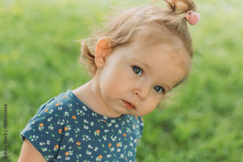 portrait of a cute little girl with blue eyes in a blue dress in the park portrait of a cute little girl with blue eyes in a blue dress in the park