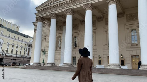 Moscow, Russia, April 28, 2022: Elegant Madame young beautiful business woman in hat and coat, going to work, walking in center of Moscow, near Bolshoi Theater. Russia. Spring. Mysterious stranger.