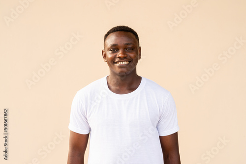 Portrait of handsome African man wearing white t-shirt while smiling