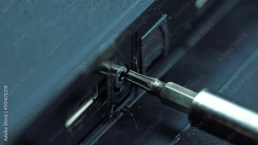 Close-up macro on screwdriver unscrewing torx screw from hard disk drive. Metal cover electronic device screwed with torx screws. Close-up macro on screwdriver unscrewing torx screw from hard disk drive. Metal cover electronic device screwed with torx screws.