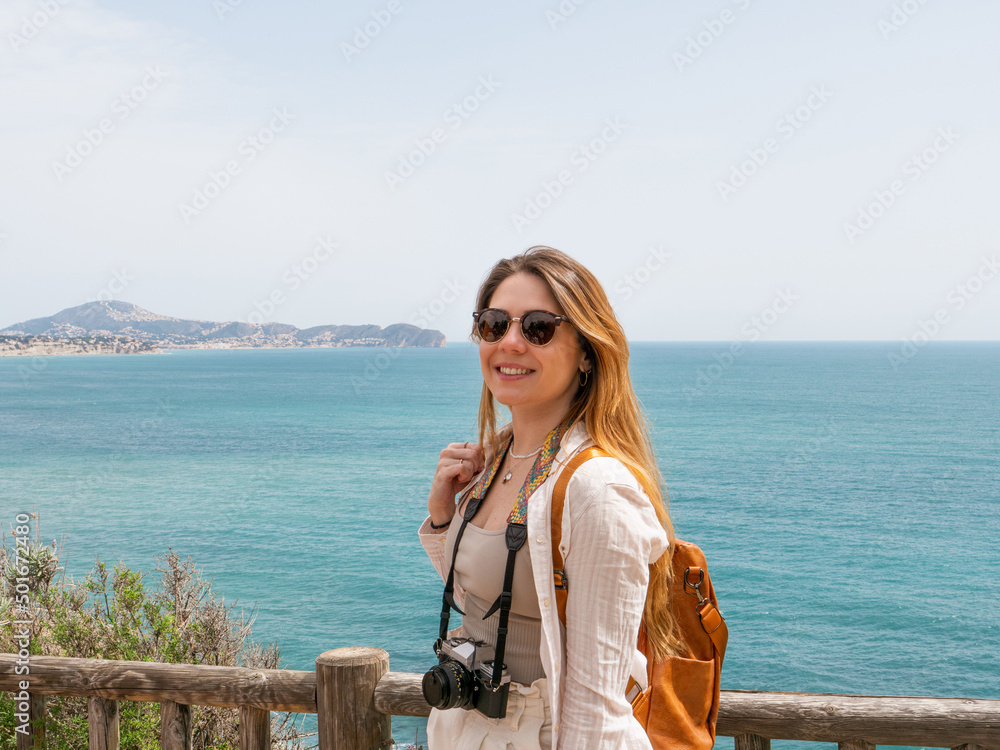 beautiful blonde woman on the beach with a camera