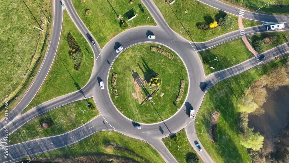 Aerial view of road roundabout intersection with fast moving heavy traffic. Urban circular transportation crossroads