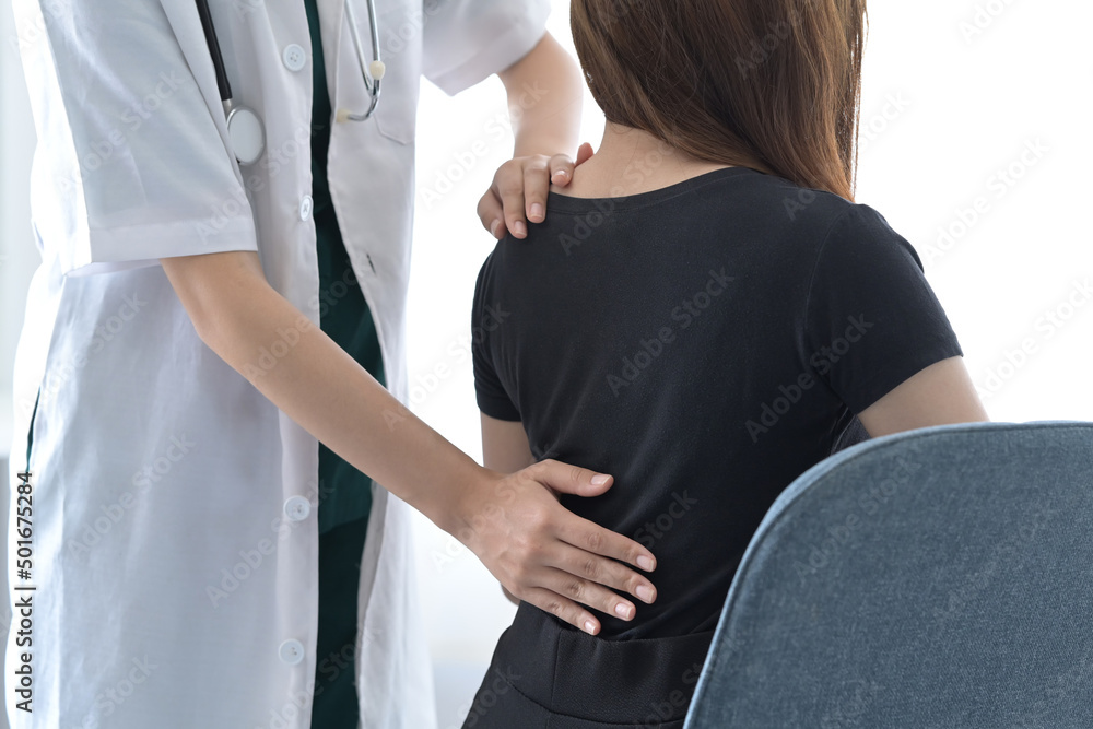 Physiotherapist examining female patient with back injuries. Physical therapy concept. Physiotherapist examining female patient with back injuries. Physical therapy concept.