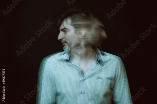 schizophrenic portrait of psychopathic man with mental disorders in white shirt on dark background © alexkoral