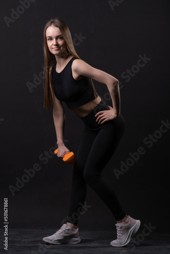 Maiden orange dumbbells a black with . On beautiful background orange two workout, from shape body in person and female care, muscle loss. Fat big adult, arms young overweight doing