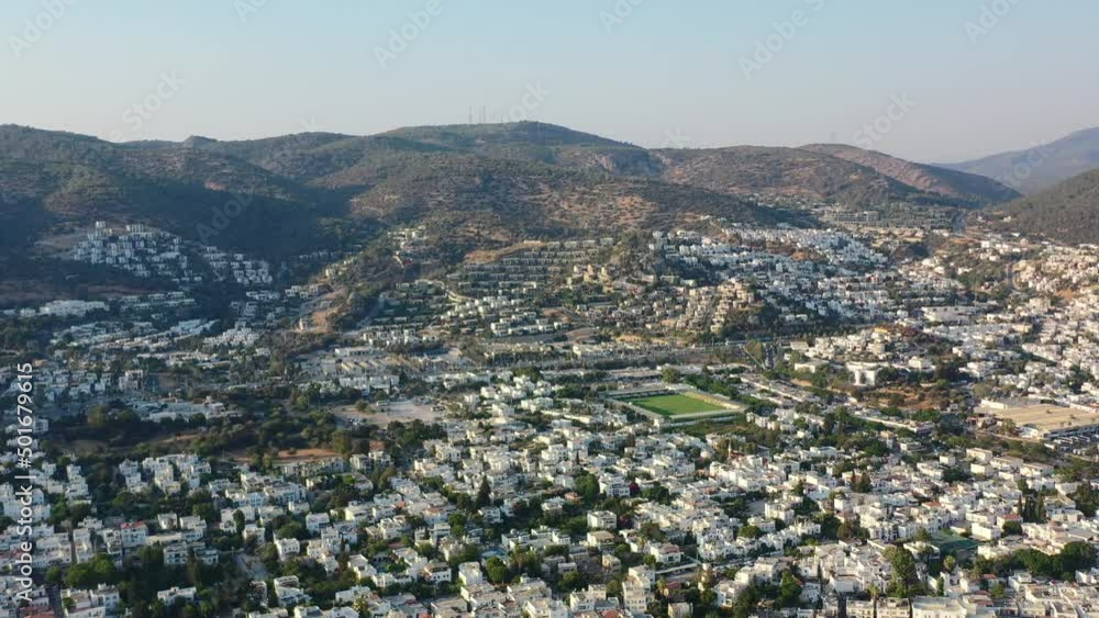 aerial view of Bodrum valley filled with white villas as the sun sets over the hills and homes in Mugla Turkey on a sunny summer afternoon aerial view of Bodrum valley filled with white villas as the sun sets over the hills and homes in Mugla Turkey on a sunny summer afternoon