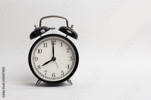 black vintage style alarm clock isolated on a white background