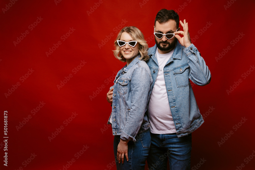 couple wearing sunglasses, happy couple on red background. place for advertising. copy space. couple wearing sunglasses, happy couple on red background. place for advertising. copy space.