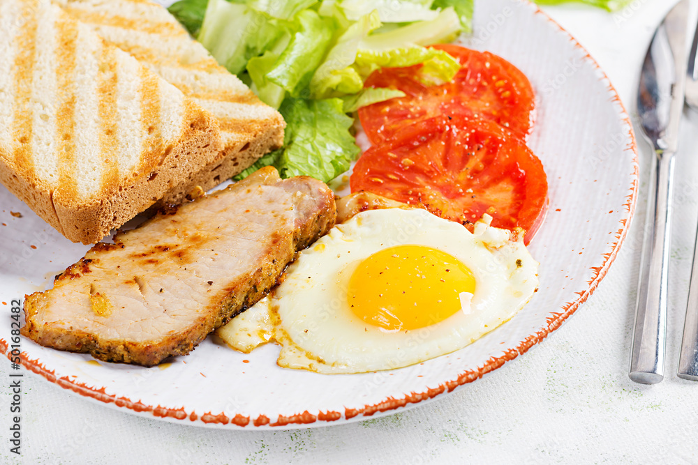 Fried egg with slice pork, tomatoes and toasts. Delicious English Breakfast. Brunch. Fried egg with slice pork, tomatoes and toasts. Delicious English Breakfast. Brunch.