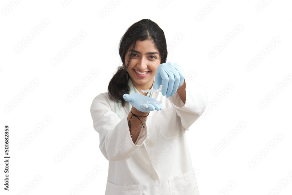 Young Venezuelan female orthodontist holding invisible dental aligners. Isolated over white background. Young Venezuelan female orthodontist holding invisible dental aligners. Isolated over white background.