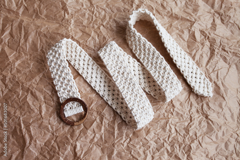 Handmade macrame belt on craft paper background. ECO friendly natural  macrame cotton belt. Hobby knitting handmade macrame. Modern summer  concept. Stock Photo
