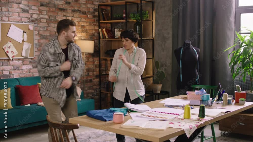 Two charismatic people are dancing and enjoying eachothers company as they dance around in the designer home office Two charismatic people are dancing and enjoying eachothers company as they dance around in the designer home office