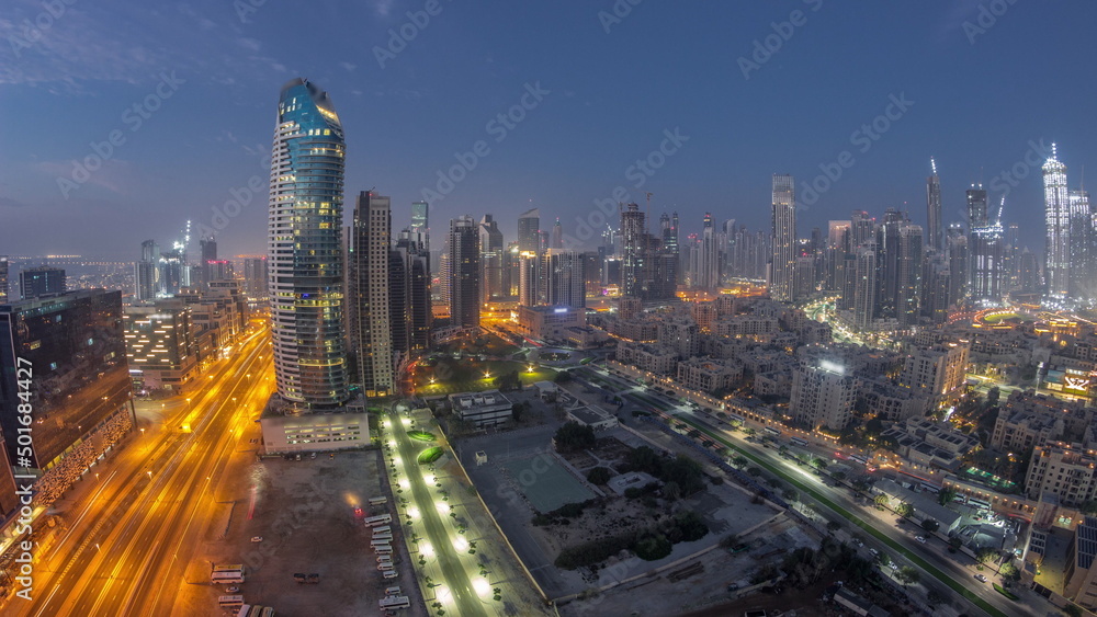 Dubai's business bay towers aerial night to day timelapse. Rooftop view of some skyscrapers