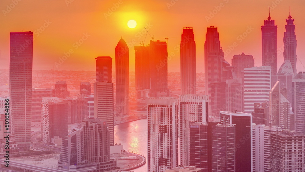 Skyline with modern architecture of Dubai business bay towers at sunset timelapse. Aerial view