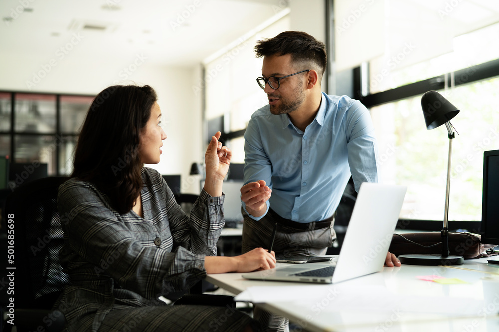Colleagues in office. Businesswoman and businessman discussing work in office.. Colleagues in office. Businesswoman and businessman discussing work in office..