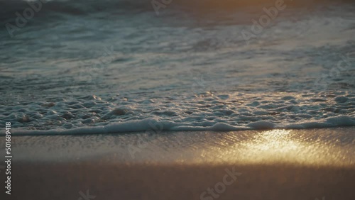 Prachtige weerspiegeling van de ondergaande zon in de wilde golven uit de stille ocean op het zandstrand La Punta in Puerto Escondido Mexico. Close-up following slwmo shot (PLEASE FIX LENGUAGE) photo